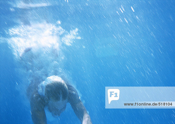 Mann taucht unter Wasser