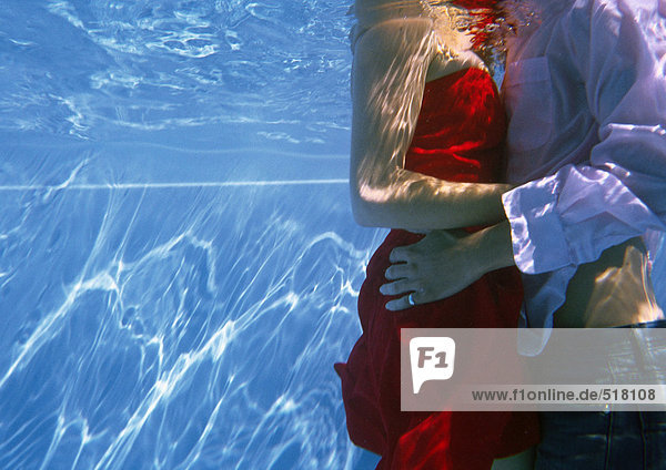 Vollständig bekleidetes Paar im Pool  Unterwasserblick