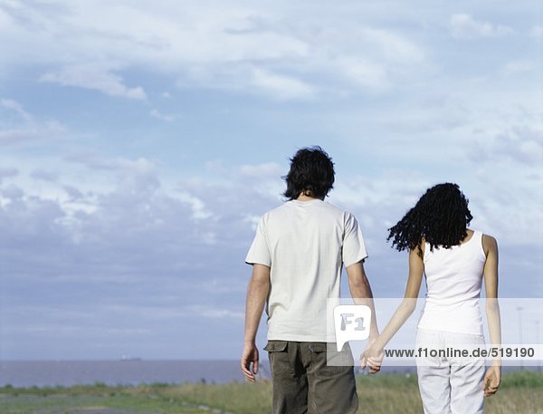 Young man and young woman walking hand in hand