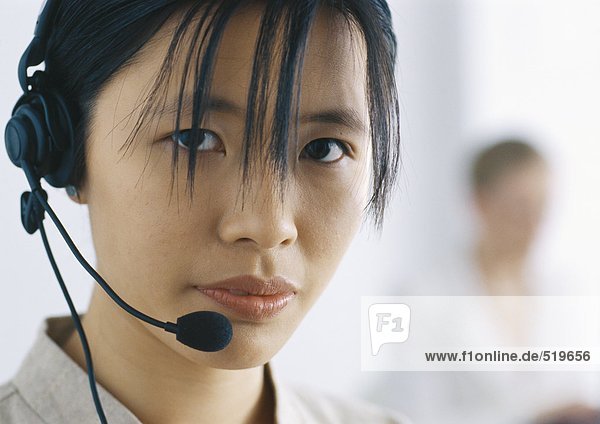 Woman with headset looking at camera