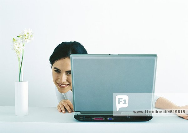 Frau schaut sich auf der Seite des Laptops um