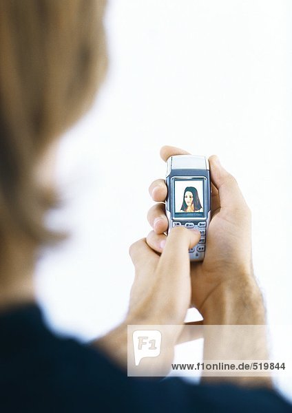 Man holding cellphone displaying woman's picture