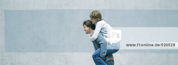 Young man carrying young woman piggyback