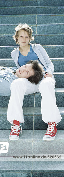 Junges Paar auf Stufen  Mann ruht Kopf auf dem Schoß der Frau