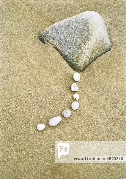 Reihe von Kieselsteinen und Felsen am Strand