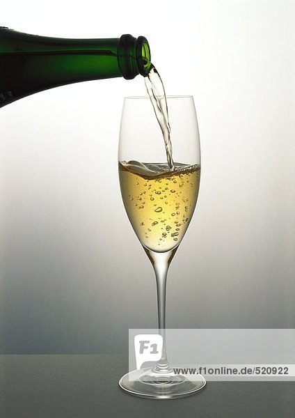 Gießen eines Glases Champagner