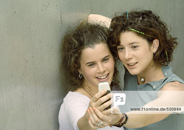 Two young women looking at camera phone