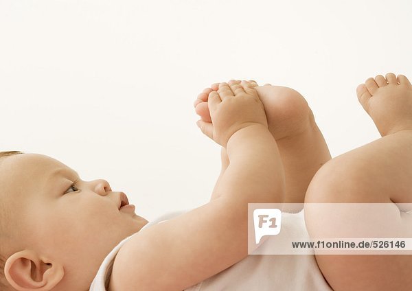 Baby lying down  holding foot
