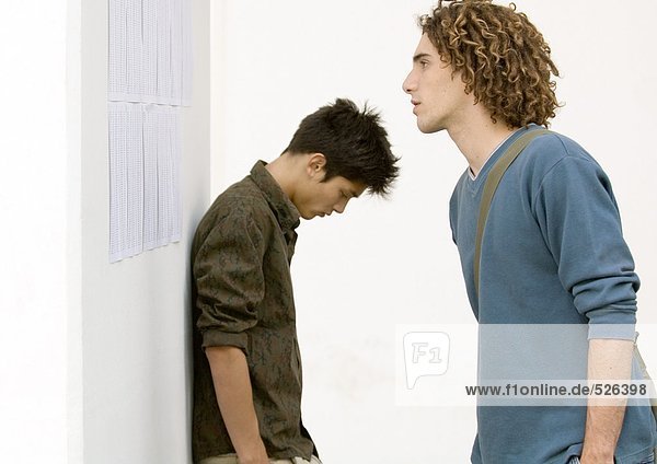 Zwei Schüler stehen in der Nähe der Ergebnisse an der Wand