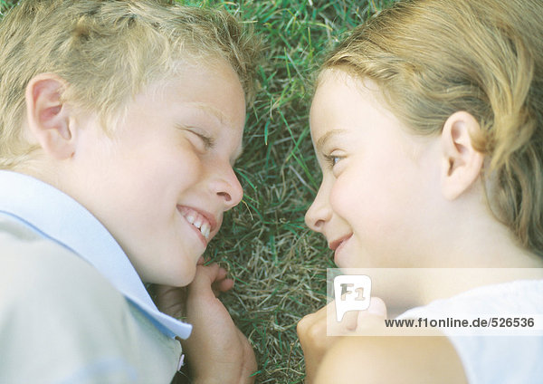 Boy and girl lying in grass  smiling