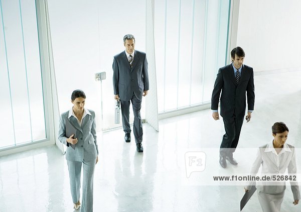 Four executives entering office building lobby