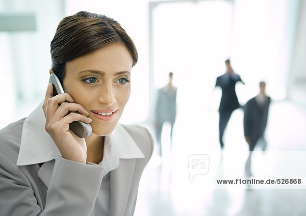 Geschäftsfrau mit Handy in der Bürolobby