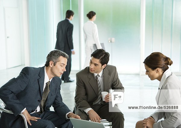 Business people sitting in lobby  having discussion