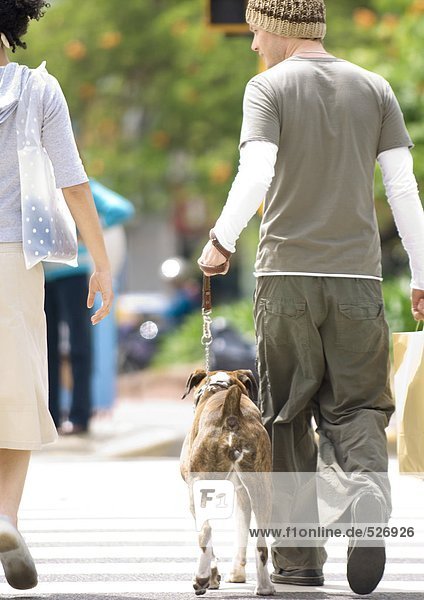 Young couple with dog crossing street