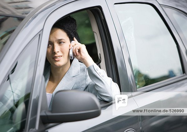 Geschäftsfrau mit Handy im Auto