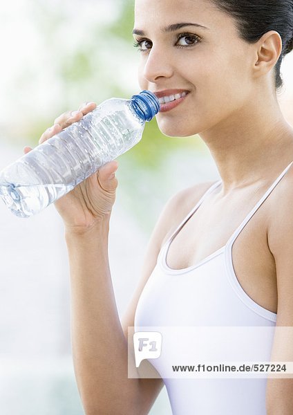 Frau trinkt Wasser in Flaschen