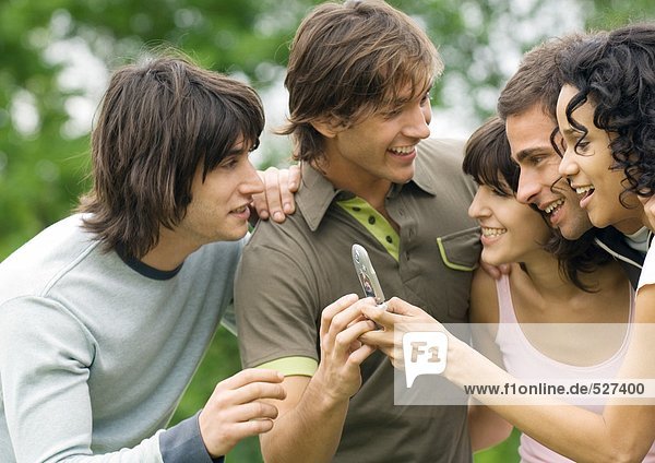 Group of young friends looking at cell phone