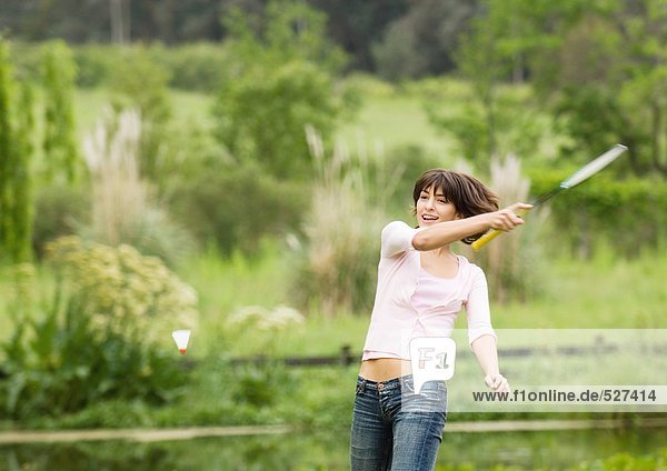 Junge Frau schwingt Badmintonschläger