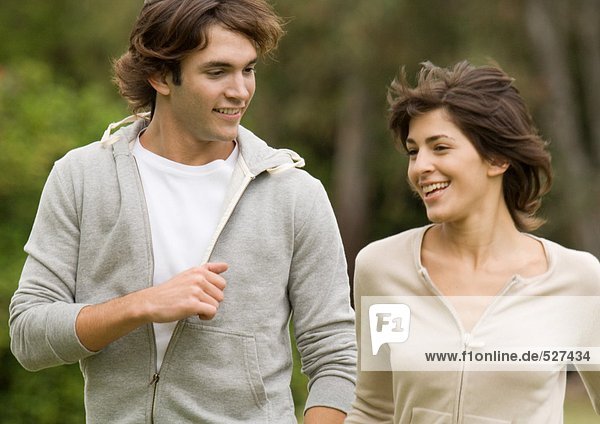 Young couple walking side by side outdoors