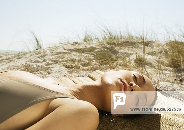 Frau am Strand liegend  Sanddüne im Hintergrund