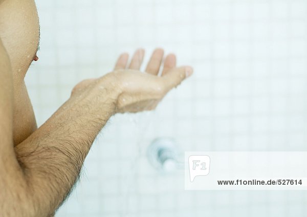 Mann hält Hand in Hand in der Dusche