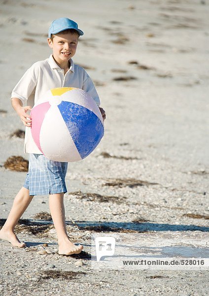 Junge mit Strandball am Strand