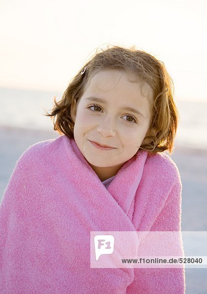 Girl wrapped in towel on beach  portrait
