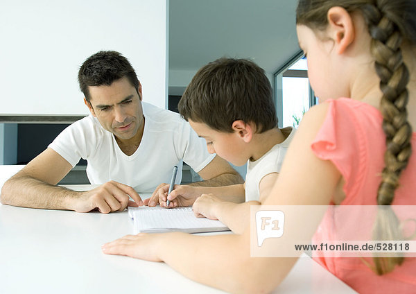 Father helping children with homework