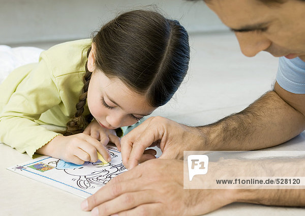 Girl coloring with father