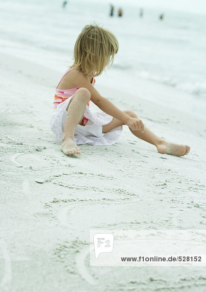 Mädchen am Strand sitzend