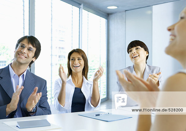 Business team clapping in meeting