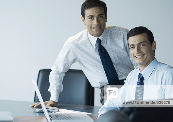 Geschäftskollegen arbeiten zusammen  lächeln vor der Kamera