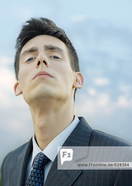 Young businessman  looking down at camera  portrait