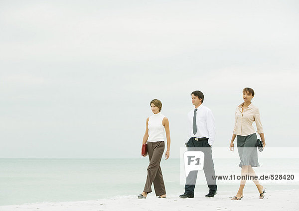 Business-Team beim Spaziergang am Strand