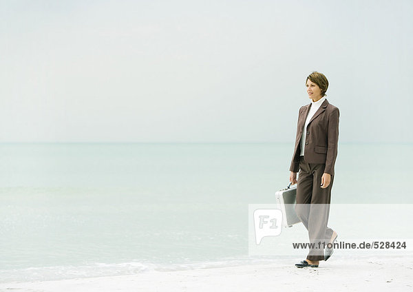 Geschäftsfrau beim Spaziergang am Strand