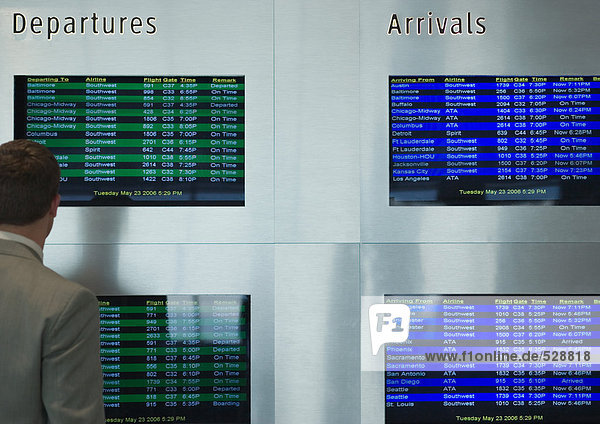 Man looking at departure board screen