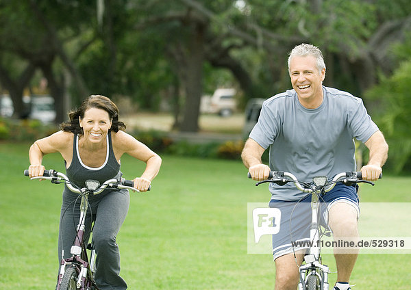 Reife Paare auf Fahrrädern  Vorderansicht