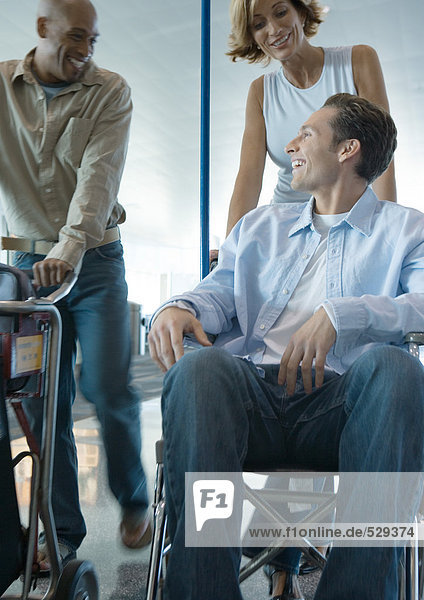 Man in wheelchair talking to friends