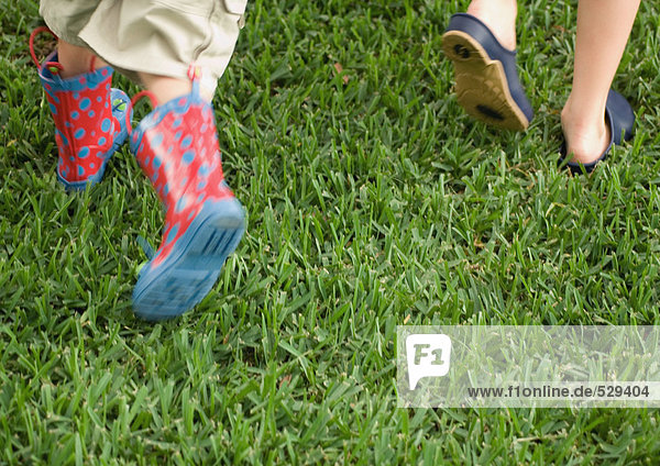 Zwei Kinder laufen über Gras  Nahaufnahme der Füße