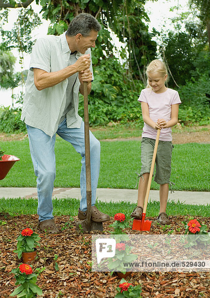 Man and girl planting flowers