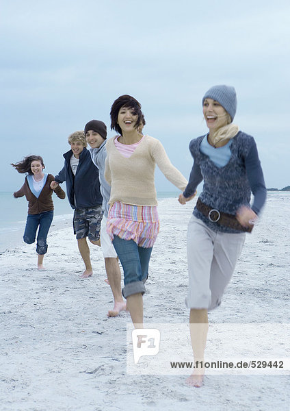 Junge Erwachsene beim Laufen am Strand
