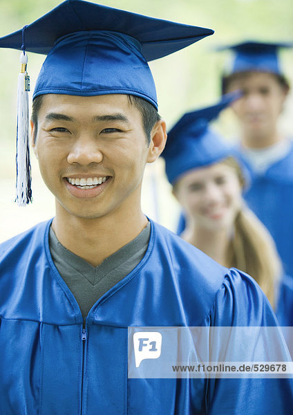 Graduates standing in line  focus on young man in foreground