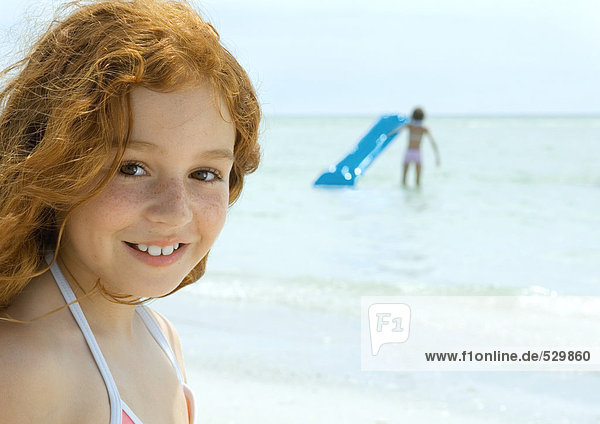 Mädchen lächelnd  Ozean im Hintergrund
