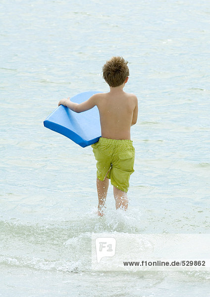 Junge beim Surfen am Strand mit Bodyboard