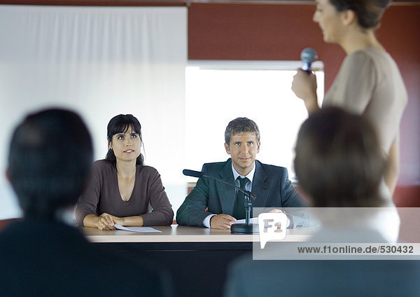 Woman speaking with microphone in conference room during seminar