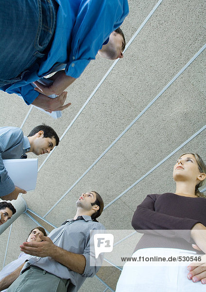 Group of young business people speaking  low angle view