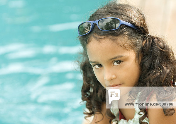 Girl with sunglasses on head  pool in background