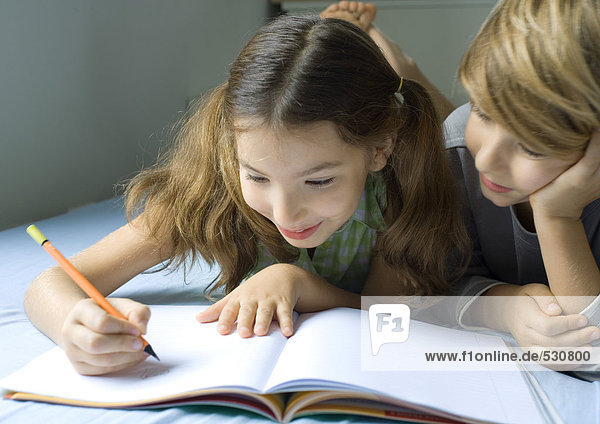 Junge und Mädchen machen gemeinsam Hausaufgaben