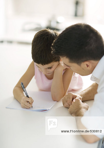 Vater hilft dem Kind bei den Hausaufgaben