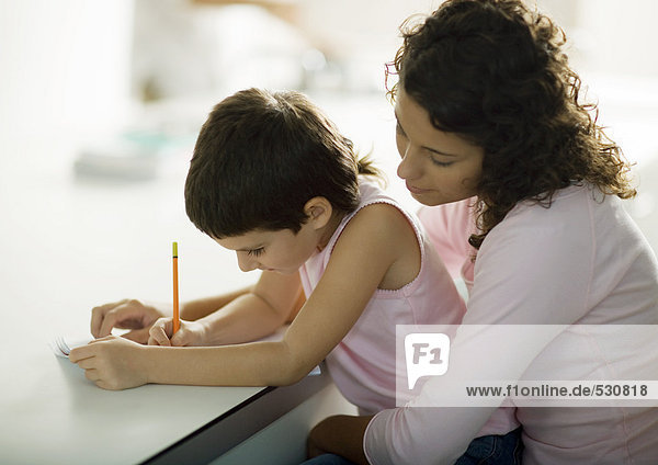Mutter hilft Kind bei den Hausaufgaben